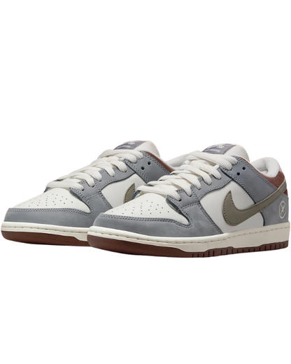 Vista lateral de las Nike SB Dunk Low Yuto Horigome Wolf Grey con Swoosh marrón y base gris