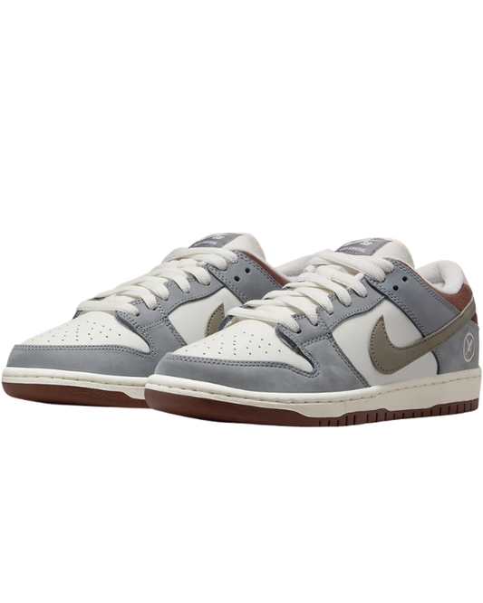 Vista lateral de las Nike SB Dunk Low Yuto Horigome Wolf Grey con Swoosh marrón y base gris